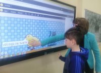 zdjęcie ucznia i wychowawczyni przy ekranie interaktywnym