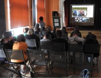 zdjęcie młodzieży i bibliotekarki oglądających prezentację