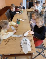 zdjęcie dzieci podczas wiązania butów z papieru