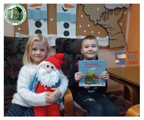 zdjęcie dziewczynki z maskotką krasnalem i chłopcem trzymającym książkę siędzących w fotelach na górze logo biblioteki