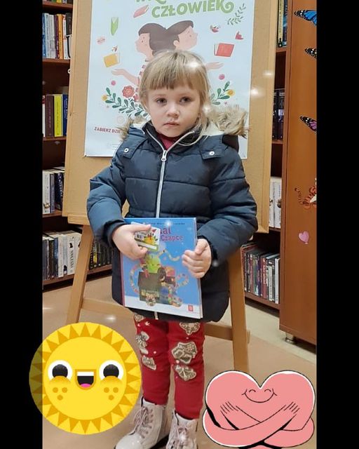 zdjęcie dziewczynki z książką na tle plakatu projektu mała książka wielki człowiek na dole obrazki serduszka i słoneczka