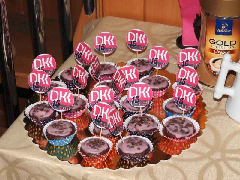 zdjęcie muffinek z wbitymi wykałaczkami z napisem 15 lat DKK