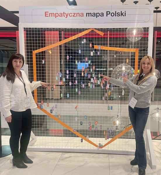 zdjęcie liderek Pracowni Orange przy wyznaczonej taśmą na siatkowej ścianie mapy Polski wskazujących na pracownię w Szprotawie