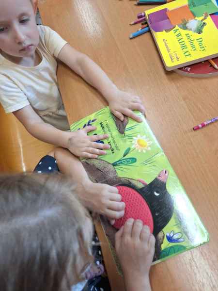zdjęcie dwójki przedszkolaków z książeczką sensoryczną