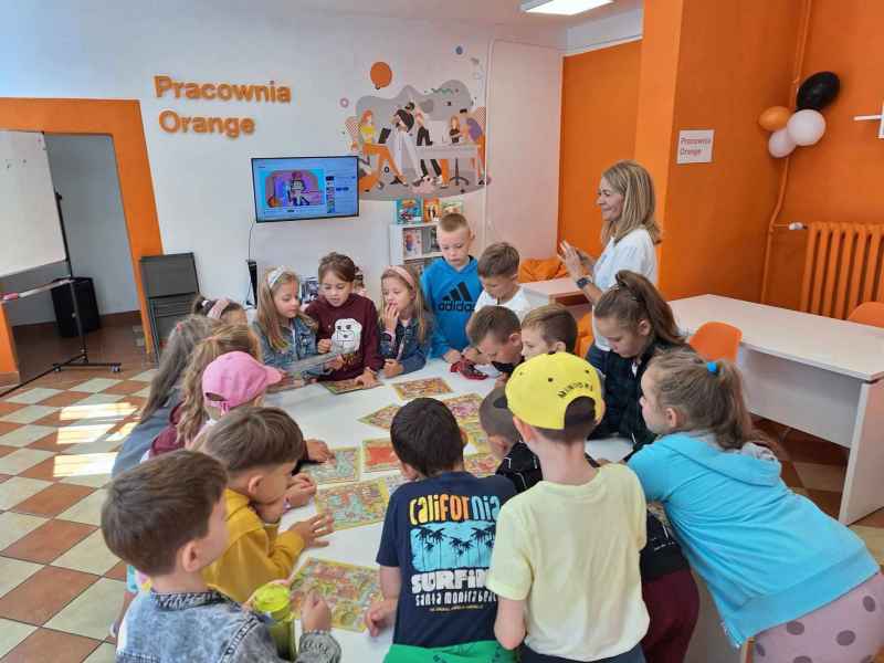 zdjęcie dzieci z wychowawcą podczas gry w planszówki w pracowni orange