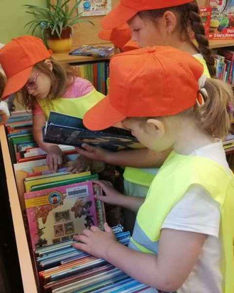 zdjęcie przedszkolaków oglądających książki w oddziale dla dzieci