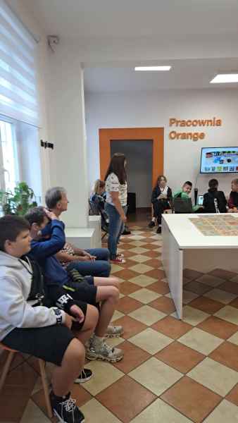 zdjęcie bibliotekarki oraz grupy szkolnej w pracowni orange