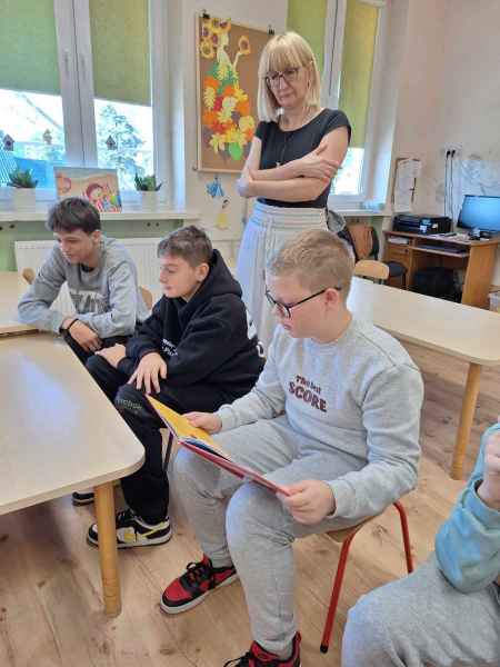zdjęcie wychowawczyni oraz chłopców w trakcie czytania