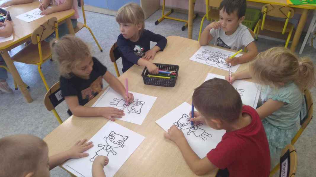 zdjęcie dzieci podczas kolorowania rysunku kotka