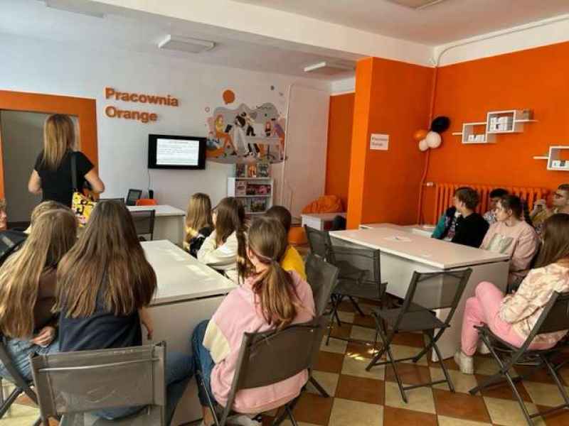 grupa młodzieży oglądająca prezentację w pracowni orange