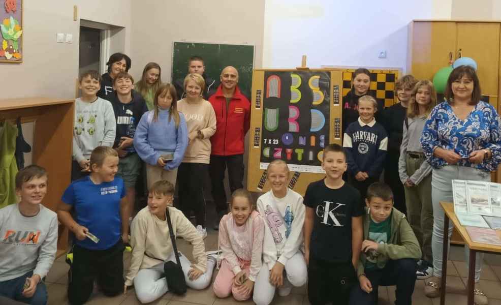 grupowe zdjęcie bibliotekarek, nauczycielki, wiceprzewodniczącym Rady Powiatu Żagańskiego oraz dzieci