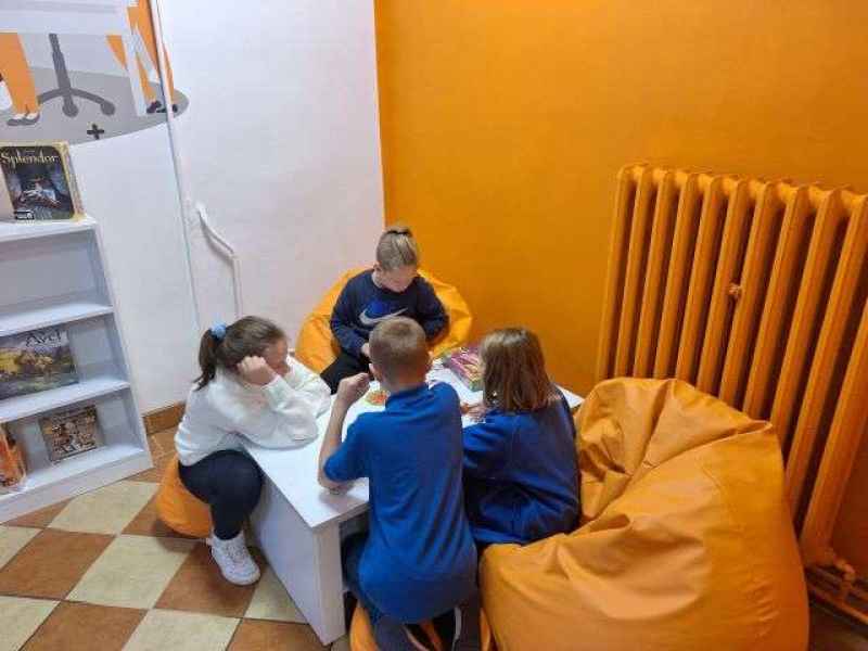 czwórka dzieci w trakcie gry w gorącego ziemniaka przy stoliku