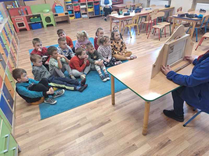 zdjęcie bibliotekarki czytającej bajkę dzieciom