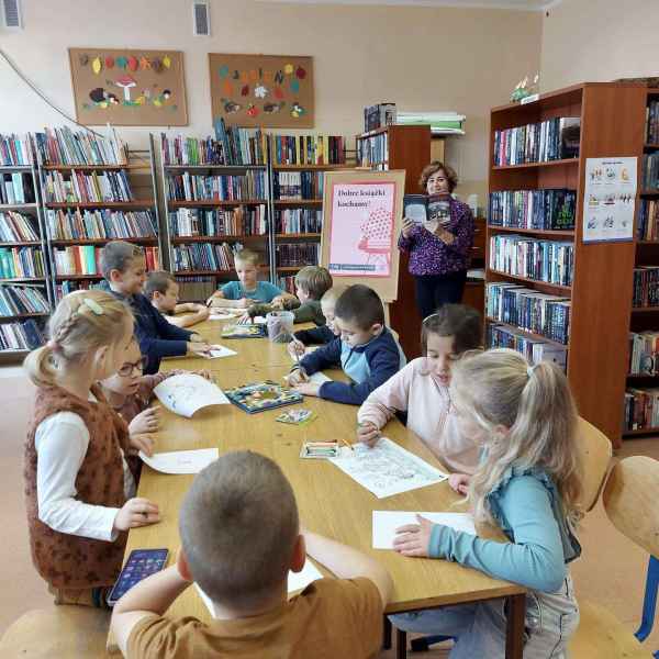 zdjęcie bibliotekarki czytającej dzieciom książkę