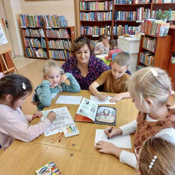 zdjęcie bibliotekarki przyglądającej się rysującym dzieciom