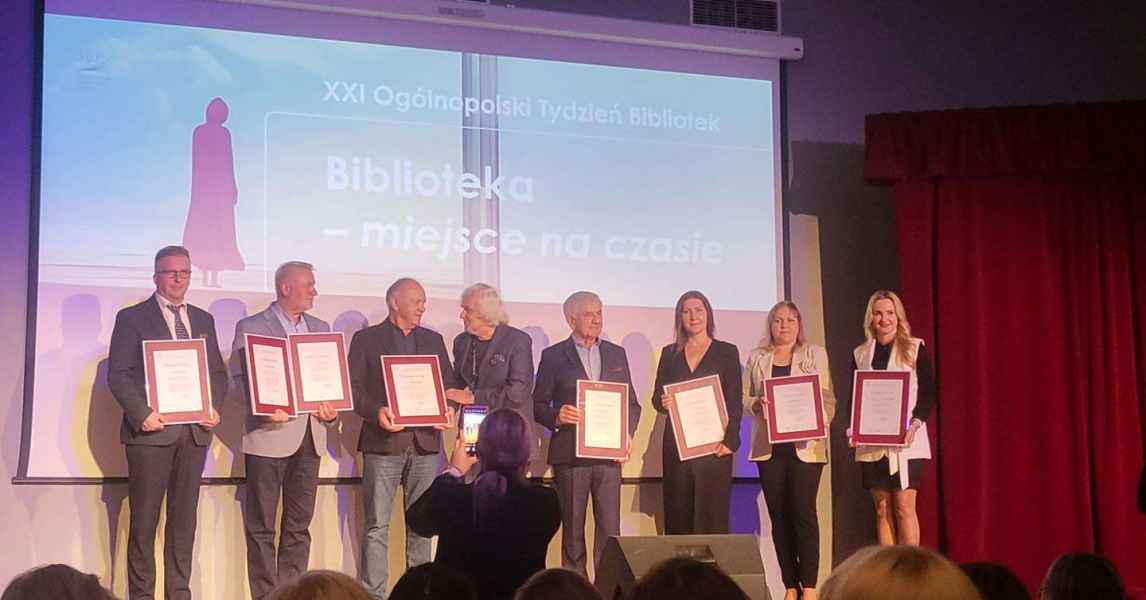 grupowe zdjęcie burmistrza Szprotawy, dyrektor biblioteki oraz innych nagrodzonych z dyplomami z dyrektorem biblioteki w Zielonej Górze