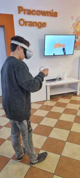 zdjęcie chłopca podczas malowania wirtualnego bałwanka w goglach VR