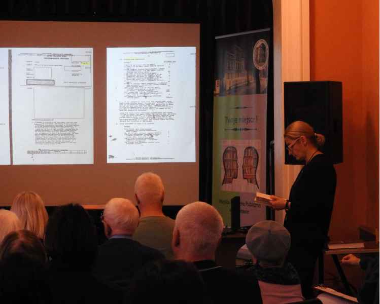 zdjęcie pisarki  i publiczności, w tle karty z tekstem z projektora
