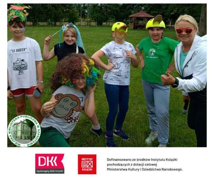zdjęcie dzieci i nauczycielki z rekwizytami i maskami, na dole logo biblioteki, DKK, instytutu książki