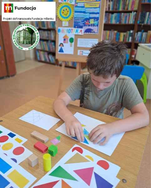 zdjęcie chłopca podczas układania wzoru z tangramu, na górze logo mfundacji z napisem projekt dofinansowała Fundacja mBanku i logo biblioteki