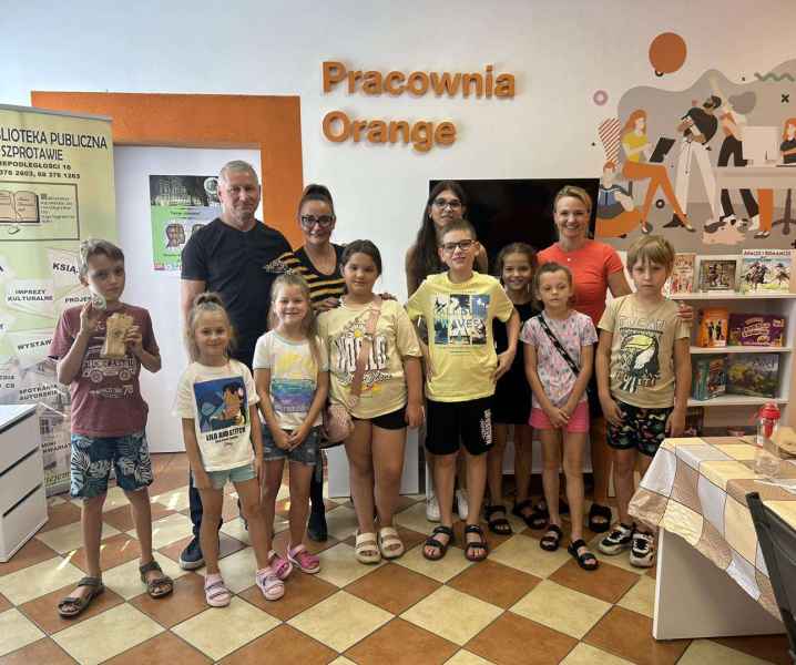 zdjęcie pszczelarzy, dyrektor biblioteki oraz dzieci w pracowni orange