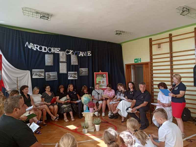 zdjęcie bibliotekarki podczas czytania i zaproszonych gości