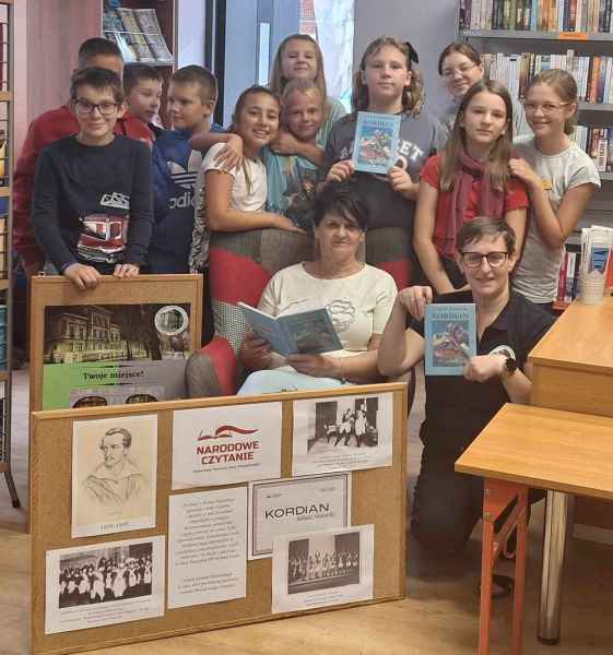 grupowe zdjęcie bibliotekarki, nauczycielki oraz młodzieży z lekturami Kordian 