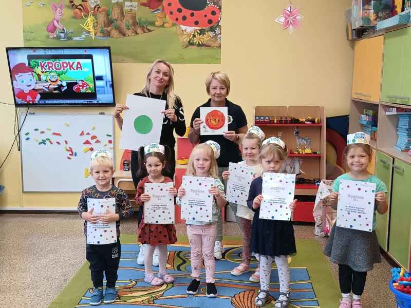 zdjęcie bibliotekarki i wychowawczyni z dziećmi i książką