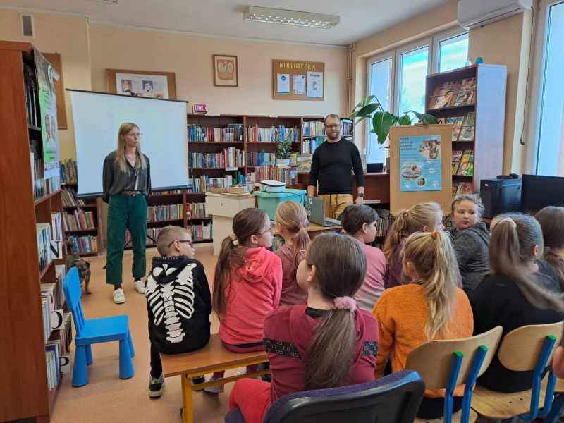 zdjęcie autorki i mężczyzny podczas opowiadania dzieciom o książce i psie Preclu