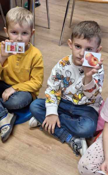 zdjęcie chłopców pokazujących karteczki z rysunkami jabłek i przetworów