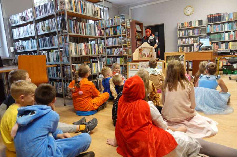 zdjęcie bibliotekarki podczas prezentacji teatrzyku kamishibai dzieciom