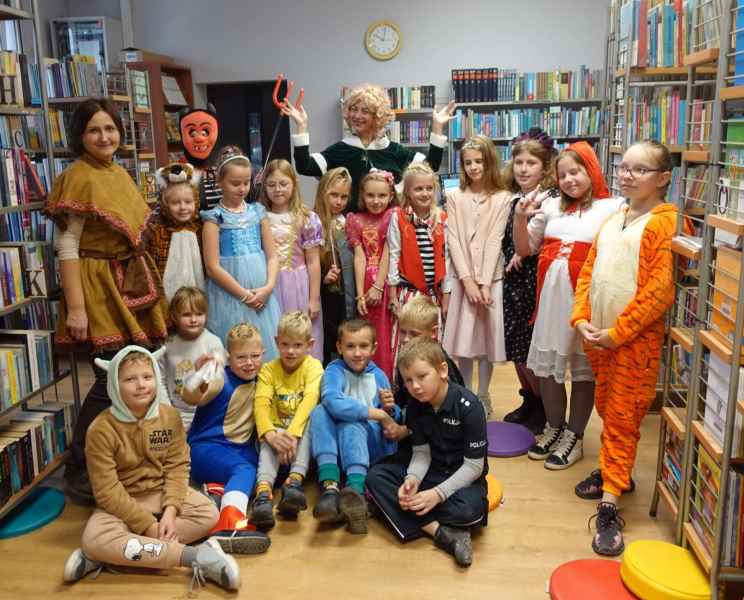 grupowe zdjęcie bibliotekarki, wychowawczyń oraz dzieci w bajkowych strojach