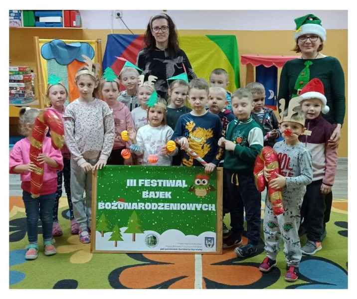 grupowe zdjęcie dzieci z plakatem projektu, wychowawczynią i bibliotekarką