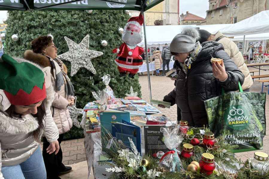 zdjęcie bibliotekarek przy stoisku i przechodniów oglądających książki na stoisku