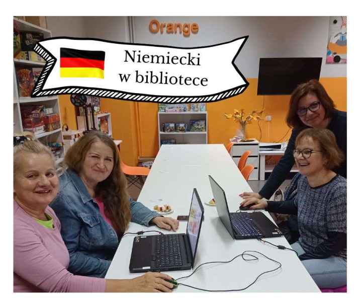 zdjęcie czytelniczek przy laptopach z bibliotekarką, na górze napis niemiecki w bibliotece obok flagi Niemiec