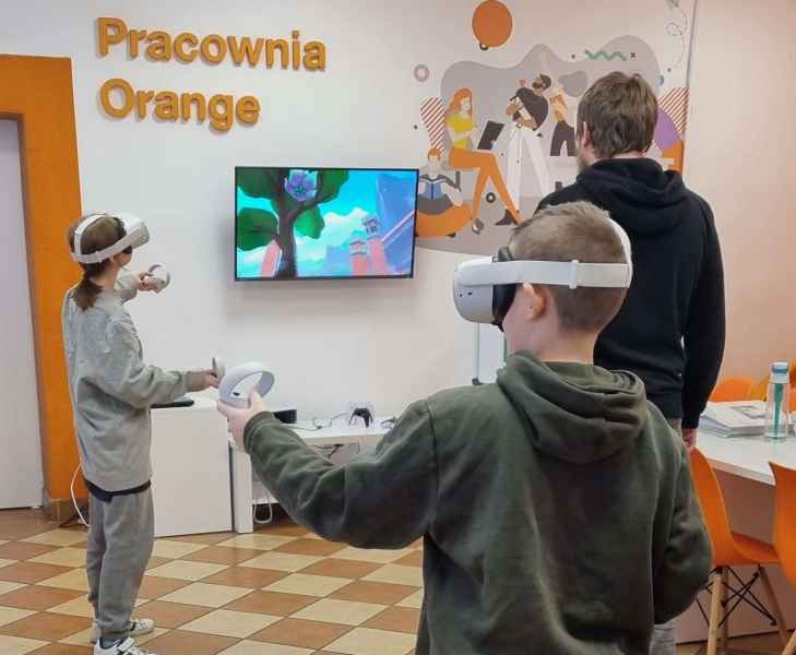 zdjęcie dzieci w goglach VR i bibliotekarza tłumaczącego zasady gry
