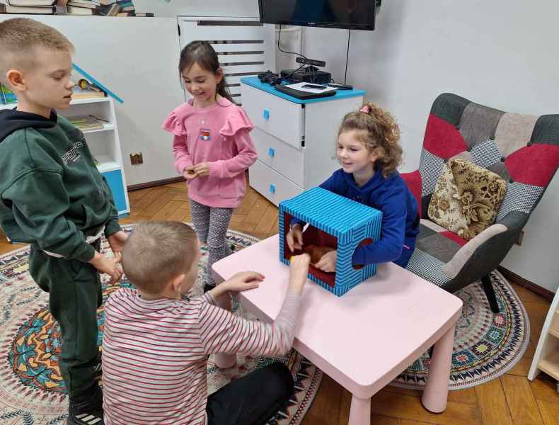 zdjęcie dzieci w trakcie zabawy sensorycznej "magiczne pudełko"