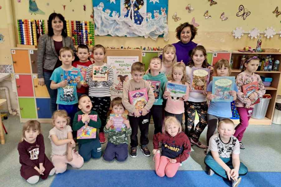 zdjęcie grupowe przedszkolaków z książkami oraz paniami z biblioteki i wychowawczynią