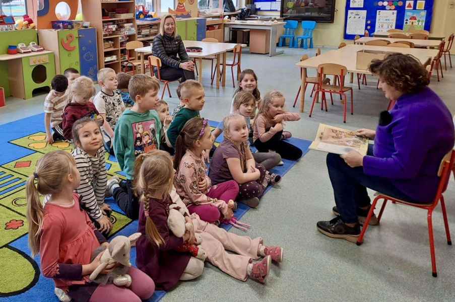 zdjęcie bibliotekarki czytającej dzieciom książkę