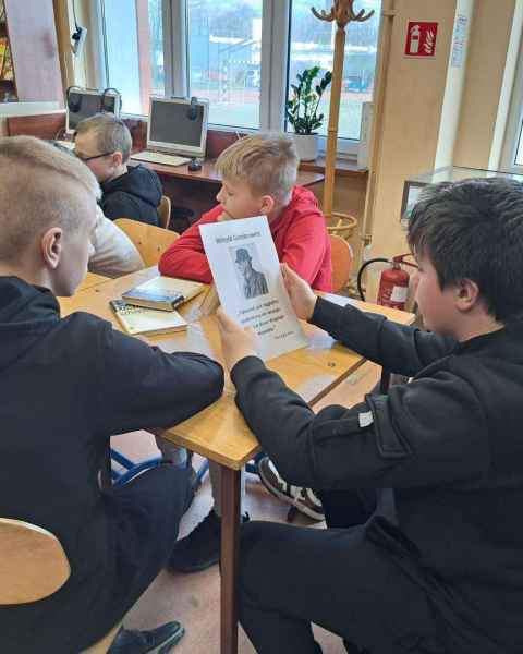 zdjęcie chłopców oglądających książki oraz kartkę z danymi autora oraz jego zdjęciem i cytatem z książki