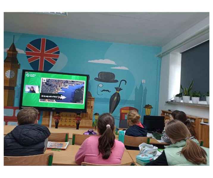zdjęcie uczniów oglądających prowadzącą na ekranie podczas spotkania online