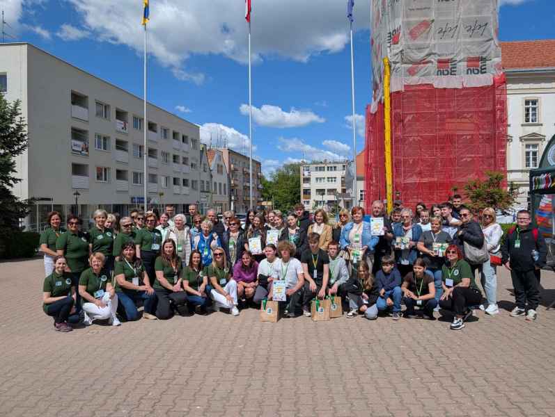 zdjęcie grupowe wszystkich uczestników i organizatorów gry miejskiej na tle budynku ratusza