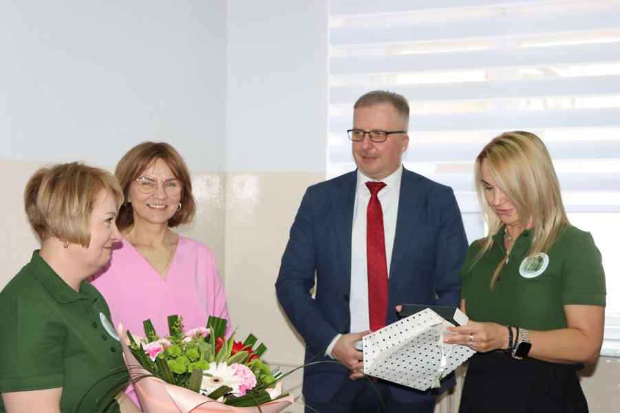 zdjęcie bibliotekarki odbierającej kwiaty i prezent z rąk dyrektor oraz życzenia od burmistrza i wiceburmistrz Szprotawy