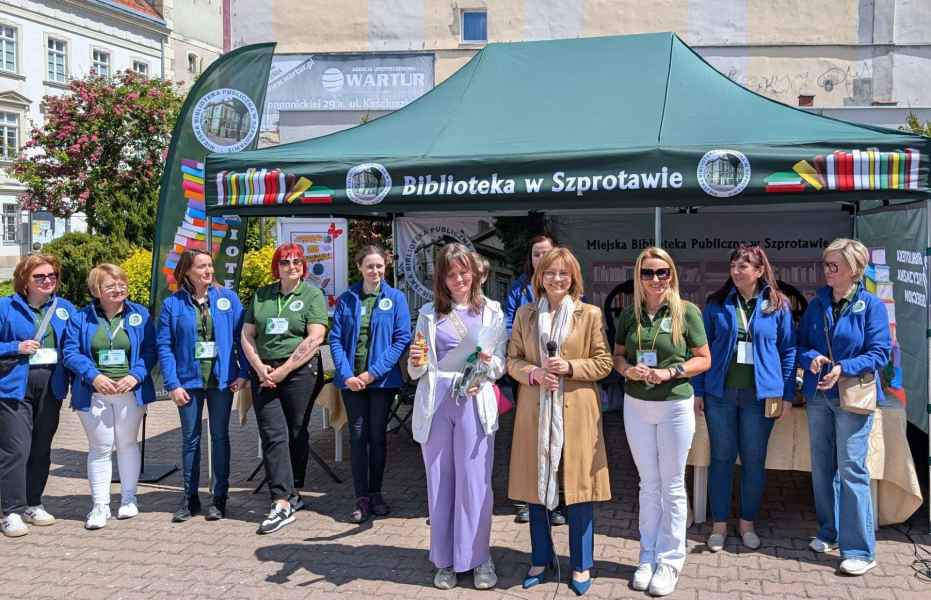 zdjęcie laureatki konkursu z dyrektor biblioteki i wiceburmistrz na tle kadry i namiotu biblioteki
