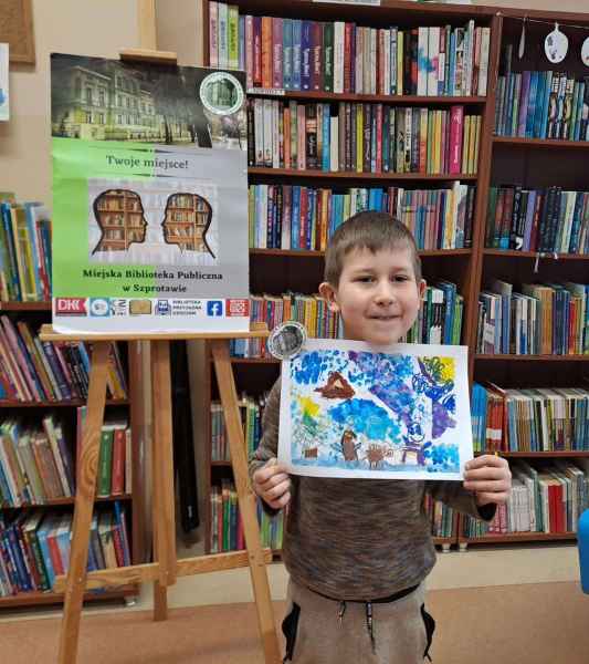 zdjęcie chłopca z zimowym pejzażem, w tle plakat biblioteki i regały z książkami