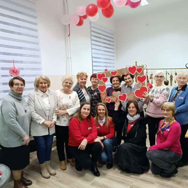 grupowe zdjęcie uczestników DKK oraz bibliotekarek z ramką w serduszka