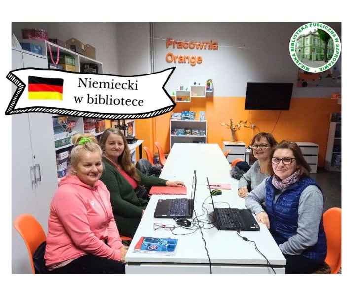 zdjęcie uczestniczek kursu z bibliotekarką przy stoliku z laptopami, na górze baner z napisem niemiecki w bibliotece i flagą Niemiec, po prawej logo biblioteki