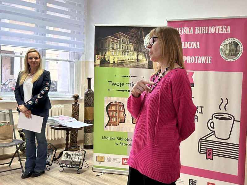 zdjęcie autorki przemawiającej do czytelników, w tle dyrektor biblioteki oraz banery biblioteki i DKK